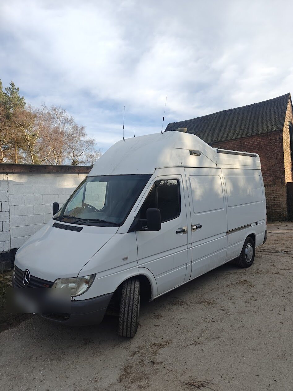 The NewsVan Mercedes Sprinter unbranded between hires, high broadcast roof and comms antennas visible